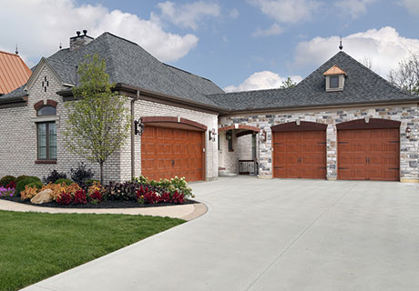 modern stone house with wooden garage doors