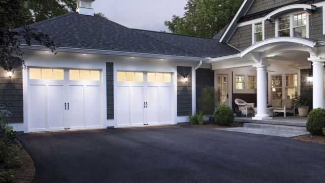 modern house with white coachman garage doors